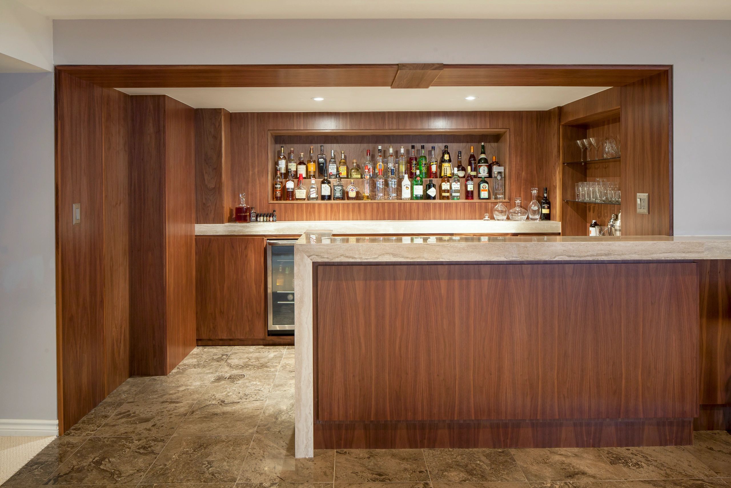 Home bar with wood paneling and spirits display