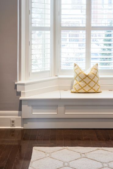 Window seat with geometric pillow and hardwood floor
